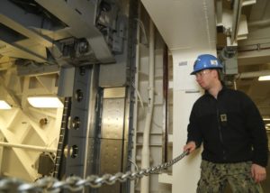 Electrician's Mate 3rd Class Mitchell McBride assigned to USS Gerald R. Ford's (CVN 78) weapons department, observes Advanced Weapons Elevator (AWE) upper stage no. 3. AWE no. 3 was accepted by the ship on February 14, the second elevator accepted on the ship. Ford is undergoing a post-shakedown availability at Huntington Ingalls Industries-Newport News Shipbuilding. (Photo: U.S. Navy)