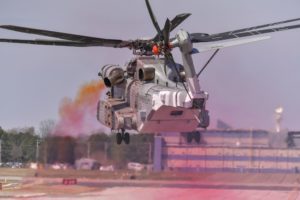 Colored oil smoke indicates rotor wake and wind effects while external “tufts” adhered to the outside of the CH-53K King Stallion show surface airflow. These efforts were used to validate a modification that mitigates Exhaust Gas Re-ingestion for the new Marine Corps aircraft in a test at Naval Air Station Patuxent River, Md. on April 4, 2019. (Photo: U.S. Navy)
