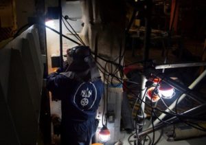 An engineer with Huntington Ingalls Industries Newport News Shipbuilding Division grinds on advanced lower stage weapons elevator aboard the aircraft carrier USS Gerald R. Ford (CVN-78) while the carrier is underway in the Atlantic Ocean on April 1, 2020. (Photo: U.S. Navy) 