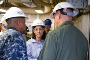 NEWPORT NEWS, Va. (June 17, 2019) Capt. John J. Cummings, USS Gerald R. Ford's (CVN 78) commanding officer, right, and Lt. Cmdr. Chabonnie Alexander, Ford's ordnance handling officer, left, brief Rep. Elaine Luria, vice chair, House Armed Services Committee-Seapower subcommittee, during a demonstration of Ford's advanced weapons elevators. (U.S. Navy photo by Mass Communication Specialist Seaman Zachary Melvin/ Released)