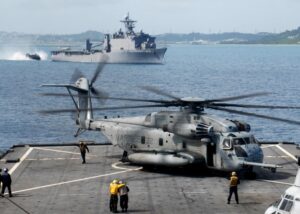 Sailors aboard the amphibious dock landing ship USS Tortuga (LSD-46) tend to a Marine Corps CH-53 Sea Stallion helicopter during flight operations in September 2009.. Nearby, the amphibious transport dock USS Harpers Ferry (LSD-49) is conducting landing craft, air cushion operations. (Photo: U.S. Navy by Petty Officer 1st Class Geronimo Aquino)