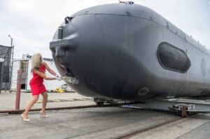 Dorothy Engelhardt, director of unmanned systems for the Deputy Assistant Secretary of the Navy for ships, christens the Orca XLUUV Test Asset System during a ceremony on April 28, 2022, in Huntington Beach, Calif. (Photo: U.S. Navy)