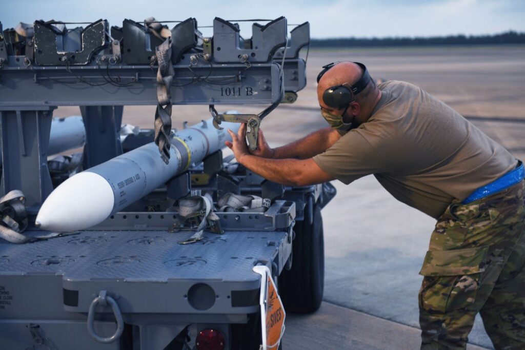 A senior airman from the 58th Aircraft Maintenance Unit loosens a strap, on an AMRAAM during Exercise Combat Archer at Eglin AFB, Fla. on June 10, 2020 (U.S. Air Force Photo)