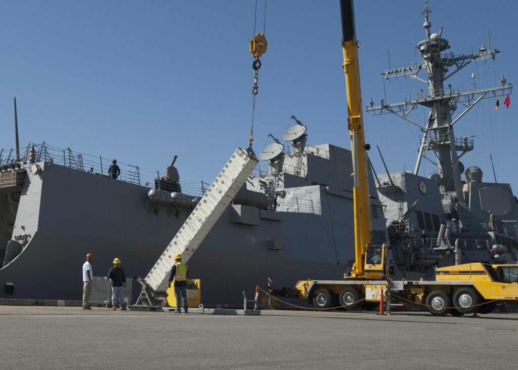 Vertical launch system missile canisters are loaded onto the guided-missile destroyer USS Pinckney (DDG -91) at Naval Weapons Station Seal Beach in 2013. (Photo: U.S. Navy by Mass Communications Specialist 1st Class Eli J. Medellin)