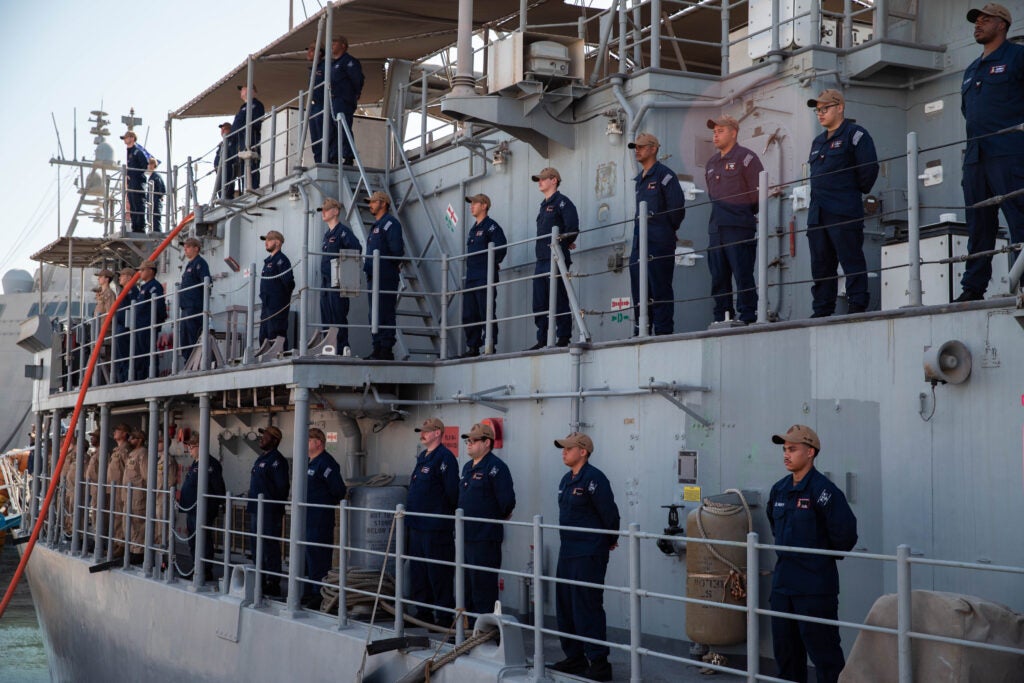 U.S. Sailors man the rails of the Avenger-class mine countermeasures ship USS Gladiator (MCM-11) during a decommissioning ceremony for the Avenger-class mine countermeasures ship USS Devastator (MCM 6) in Manama, Bahrain, Sept. 25. (Photo: U.S. Army)