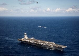 Four Carrier Air Wing 8 F/A-18 Super Hornet aircraft fly over the USS Gerald R. Ford (CVN-78) aircraft carrier while underway in the Mediterranean Sea on March 22, 2026 during a deployment in the U.S. 6th Fleet area of operations. (Photo: U.S. Navy by Mass Communication Specialist 2nd Class Tajh Payne)