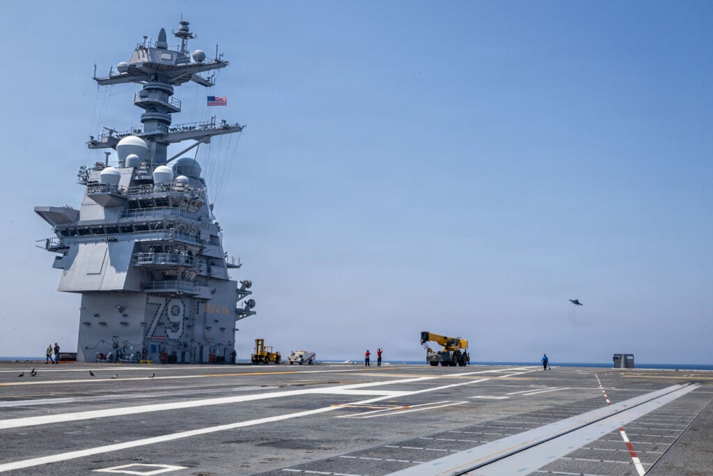 An F/A-18E Super Hornet attached to the “Salty Dogs “of Air Test and Evaluation Squadron (VX) 23, flies over the flight deck of Pre-Commissioning Unit John F. Kennedy (CVN 79) during Acceptance Trials on August 13, 2026. (Photo: U.S. Navy by Mass Communications Specialist Seaman Jayden Howard)