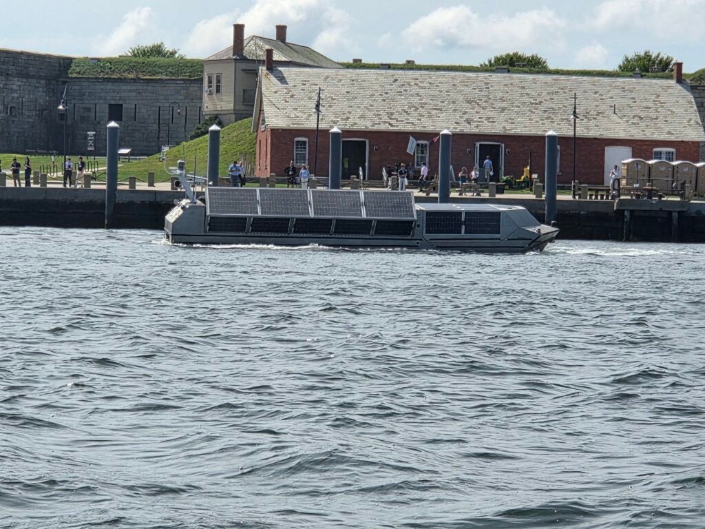 A Voltaic Marine AEU39 30-foot aluminum unmanned surface vessel integrated nto Anduril’s lattice software during the BlueTide 2026 showcase and demonstration event in Newport, RI. The vessel features a reconfigurable striker that opens from a clamshell opening at the front and can launch unmanned drones from an opening in the mid-section. (Photo: Richard Abott/Defense Daily