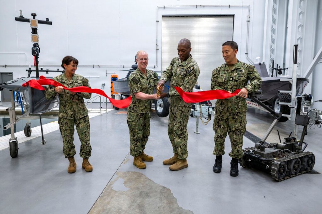From left to right, Vice Adm. Yvette Davids, Deputy Chief of Naval Operations for Operations, Plans, Strategy, and Warfighting Development, Chief of Naval Operations Adm. Daryl Caudle, Rear Adm. Melvin Smith, commander of Submarine Group Two (COMSUBGRU 2), and Lt. Cmdr. Johnny Kim, the senior attending representative for the Direct Reporting Portfolio Manager for Unmanned Systems, cut the ribbon at a ribbon cutting ceremony for the Robotic and Autonomous Systems Warfighting Development Center on Joint Expeditionary Base Little Creek-Fort Story in Norfolk, Va. on Sept. 24, 2026. (Photo: U.S. Navy by Mass Communication Specialist 1st Class John Bellino).